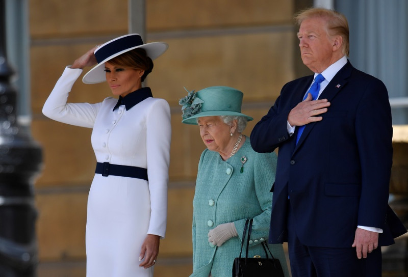 美國總統川普與夫人梅蘭妮亞（Melania）與英女王在宮前聆聽美國國歌。   圖：達志影像/路透社
