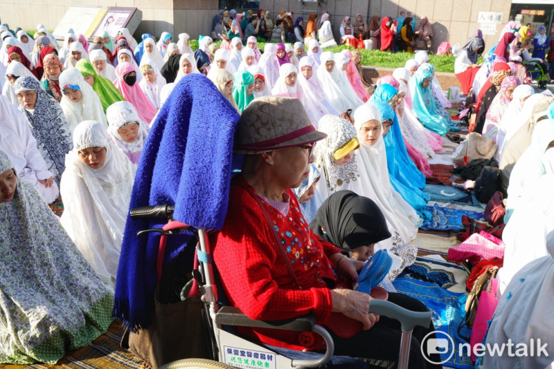 一位阿嬤跟著照顧她的穆斯林移工參加開齋節晨禱。   圖：張良一/攝