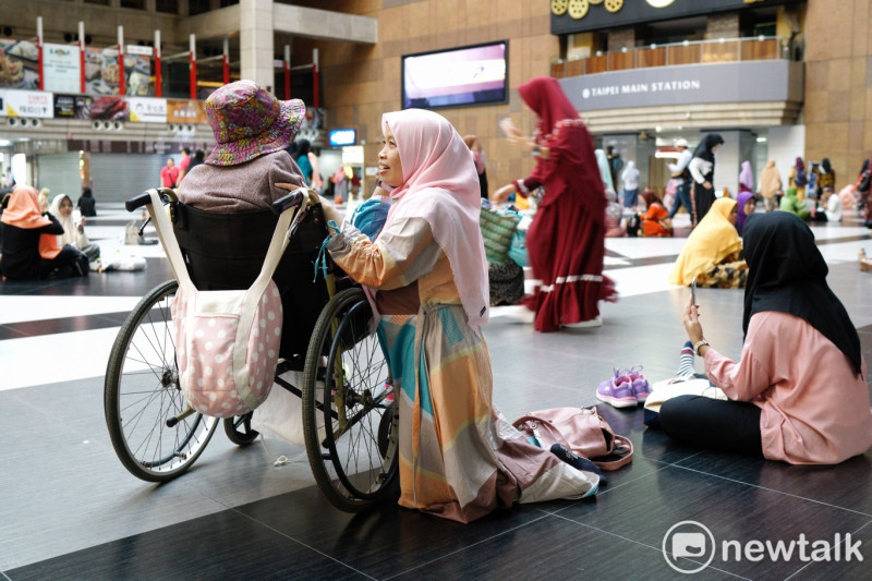 一位穆斯林移工帶著她照顧的阿嬤參加開齋節活動。   圖：張良一 / 攝