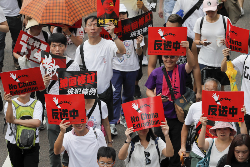 香港9日發起反送中遊行，民眾手持鮮紅色標語，表達不滿。   圖：達志影像/美聯社