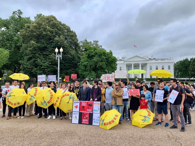 美國白宮前出現聲援香港香送中遊行人群，男女老少都有，他們高舉黃雨傘呼口號，表達訴求。   圖：翻攝自全球集氣反送中臉書