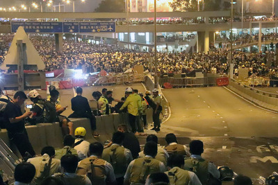 12日前往香港立法會前抗議逃犯條例修訂的民眾，在下午遭警方驅離後，晚間9時過後已轉往不遠處的中環鬧區，繼續與防暴警察對峙。警方目前已暫停清場行動。   圖：中央社