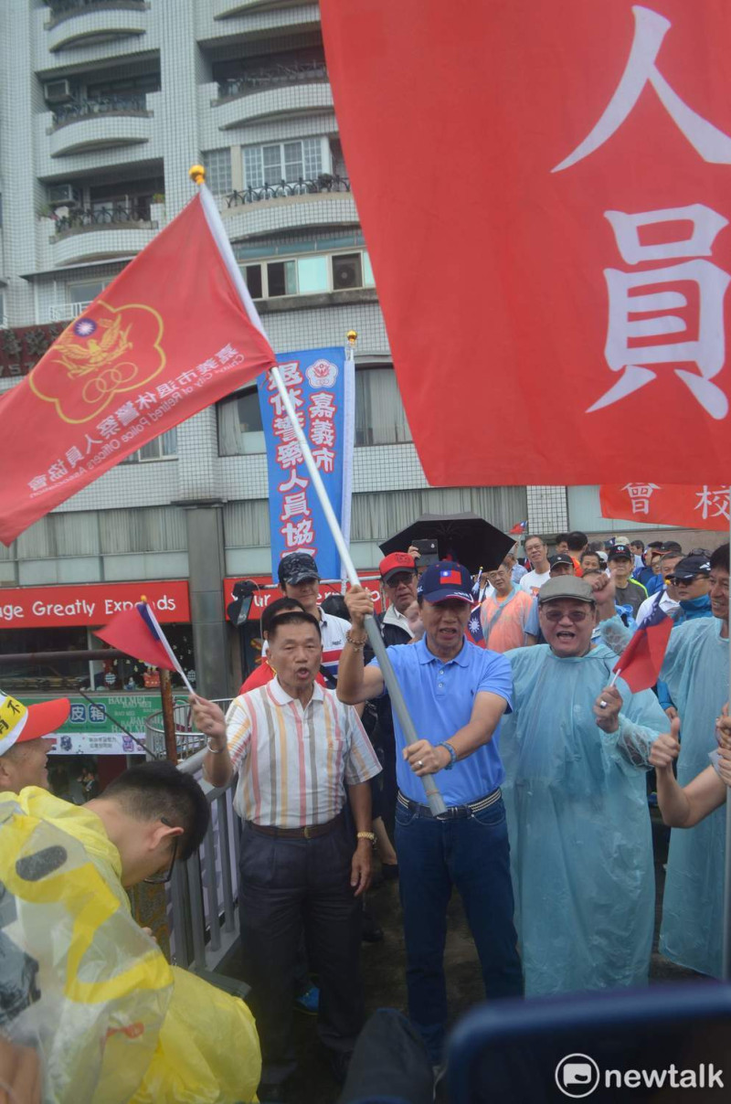 郭台銘在天橋上揮舞大旗，聲援退休警消對蔡政府的抗議。   圖：蔡坤龍/攝