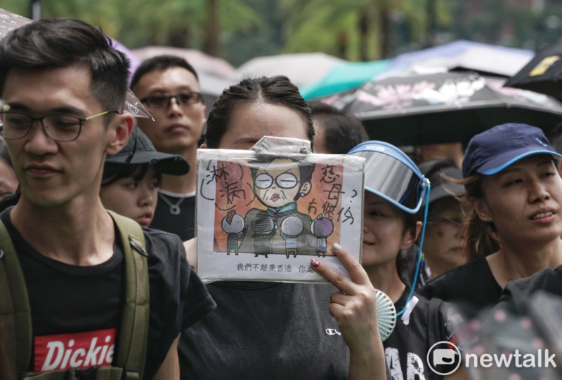 香港民眾拿著有林鄭月娥的畫報，寫著「我們不離棄香港 你走」。   圖：張良一 / 攝