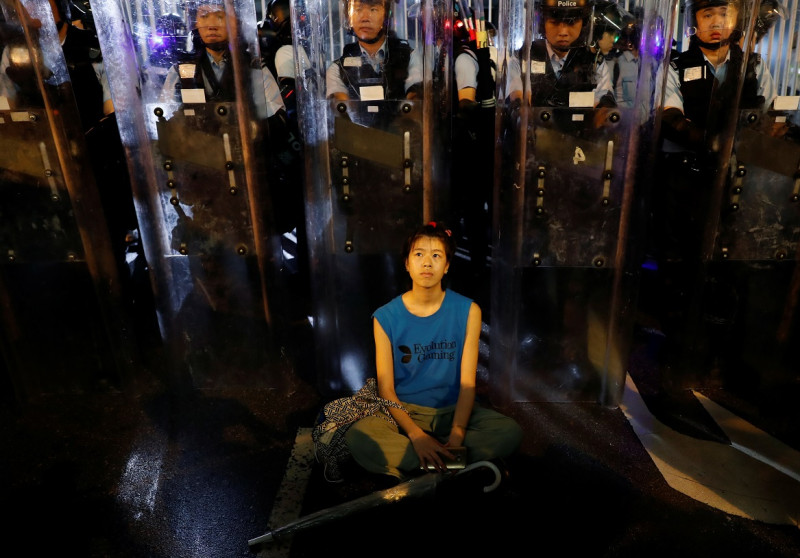 香港民眾連日發起「反送中」示威，抗議逃犯條例進行，在警民衝突與對峙之中，也出現了許多令人印象深刻的畫面，其中，一名在鎮暴警察警盾前冥想靜坐表示抗議的女子，畫面被媒體捕捉下來。   圖：達志影像／路透社