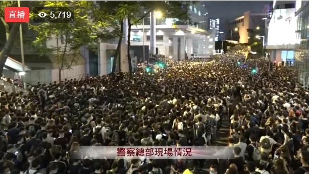 大批香港市民今（21）日中午包圍位於灣仔的警察總部，入夜後人潮越來越多，估已逾萬人。   圖：翻攝香港電台視像新聞臉書