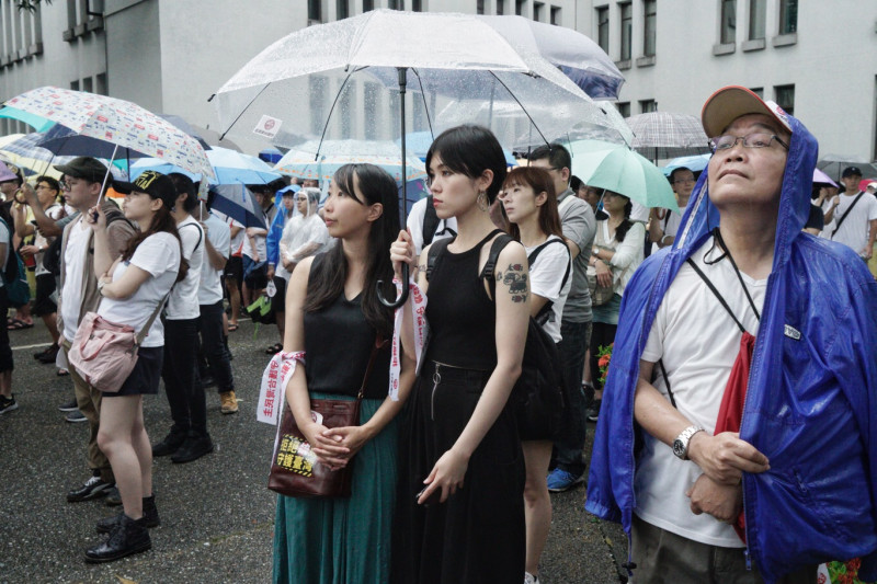 反紅媒遊行，民眾撐著傘，手綁著遊行布條，參與遊行活動的每一刻。   圖：張良一/拍攝