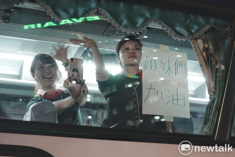 執勤完畢的長榮空服員在交通車貼出「我們來了」、「姐妹們加油」等字，向在長榮航運大樓前抗爭的長榮空服員加油打氣。（23日攝）   圖：張良一／攝