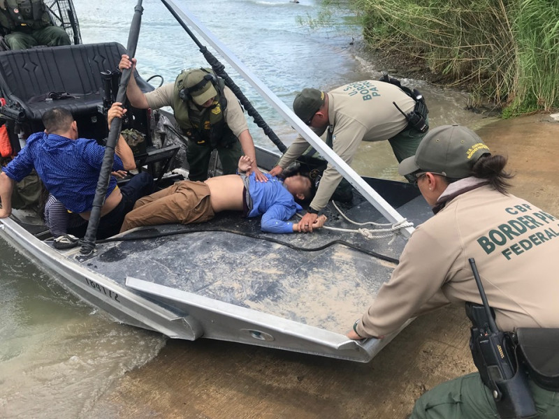 美國邊境管理人員在美墨邊界的里奧格蘭德河救起1名13歲少年（中），當時他已無反應。   圖：翻攝自美國白宮臉書