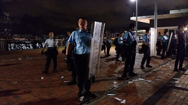 香港民眾昨晚聚集在中環海殯抗議，與警方爆發衝突。圖為港警初至抗議現場，後方可見「反送濱」標語。   圖：取自臉書粉絲專頁「廢青事務委員會 Commission of Weird Youth」