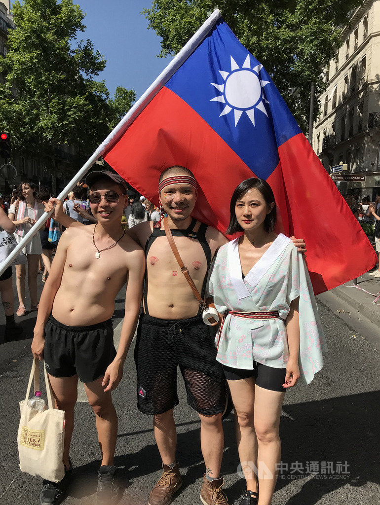 旅居巴黎7年的謝誠（中）如往常在社群網站號召台灣人一起上街參與巴黎同志遊行。他舉著國旗，在群眾中相當醒目，不時有人上前攀談，或表達對台灣的支持。   圖/中央社