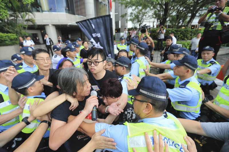 香港主權轉移22週年，但反對港府修訂逃犯條例的示威人士試圖擋住馬路，阻止升旗典禮，與警方發生衝突。   圖：達志影像/美聯社