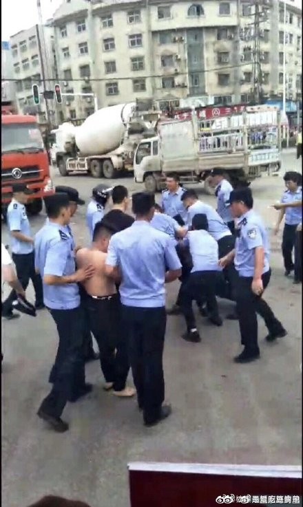 警中國湖北因為居民抗議興建大型焚化爐，爆發大規模的群眾抗議事件，警察當街毆打抗議民眾。   圖 : 翻攝自微博。