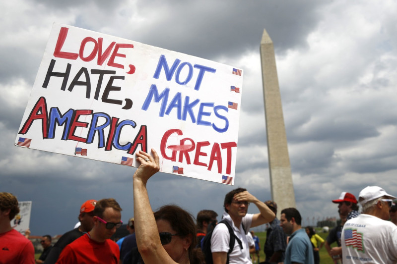 有民眾手持「愛讓美國強大，而非仇恨」標語，到場歡慶美國國慶。   圖:美聯社/達志影像