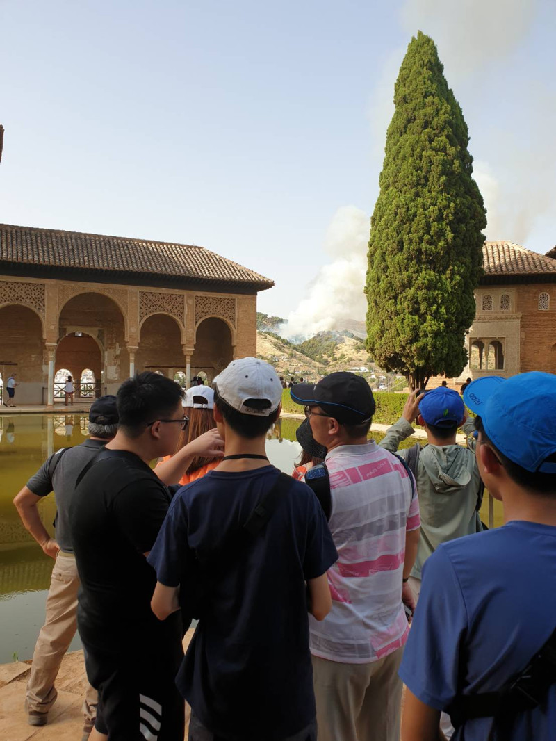 台灣旅行團正好在西班牙阿爾汗布拉宮遊覽，目擊山林火災，議論紛紛。   