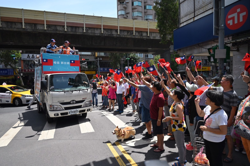 郭台銘今早在台北市街頭車隊掃街拜票，支持群眾在路邊揮舞國旗力挺。   圖：郭台銘競選辦公室／提供