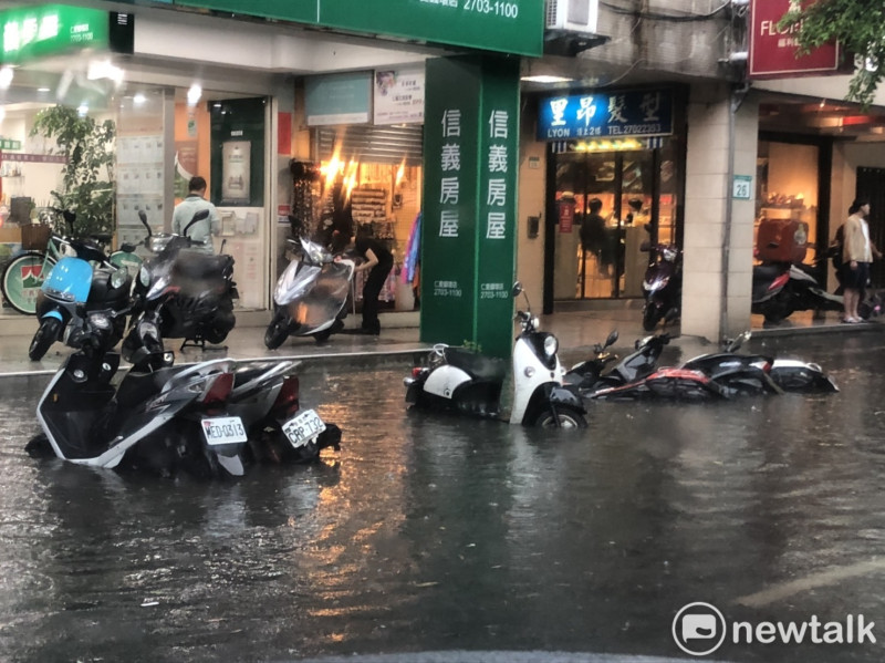 今（22）日中央氣象局針對台北市發布豪雨特報，台北市仁愛敦化路口已有機車泡水之情形。   圖：新頭殼/提供
