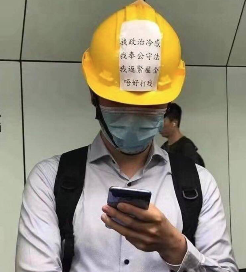 香港元朗爆發暴力事件後，網路上瘋傳港民上半族戴著頭盔上班，上面寫著「我政治冷感，我奉公守法，要趕快回家去，不要打我」。   圖：翻攝自陳芳明臉書