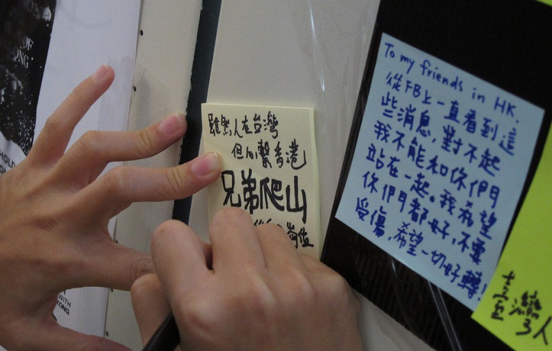 一群網友26日晚間在台北市公館商圈地下道設立「連儂牆」。一名在台港人留言寫到「兄弟爬山，各有各做」。   圖：中央社