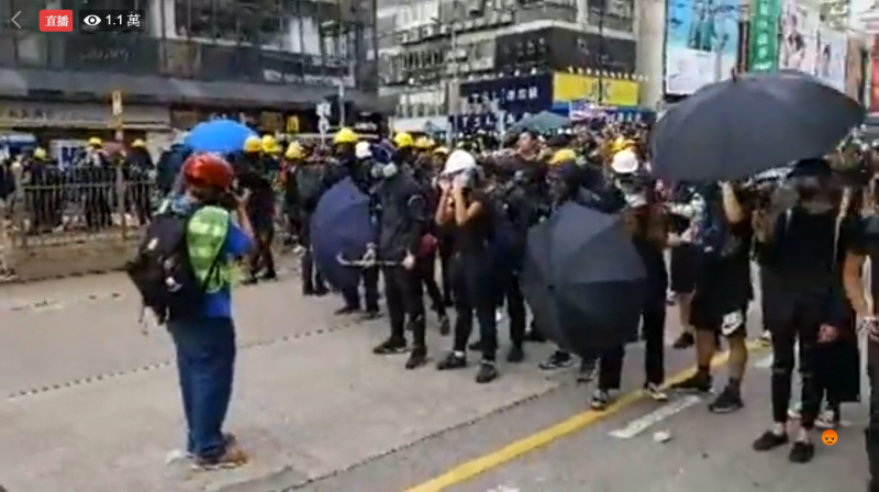 香港727「光復元朗」遊行，傳港警17:18舉起黑旗，並使用催淚彈攻擊示威遊行民眾。   圖：翻攝網路直播