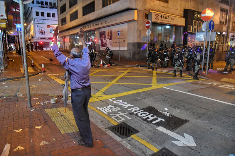 香港反送中活動28日持續延燒，港島市區猶如大型游擊戰場，大批警力晚間強勢驅離示威民眾，一名家住上環的市民深夜返家，看見鎮暴警察隨即高舉雙手，表明自己並非示威者。   圖／中央社