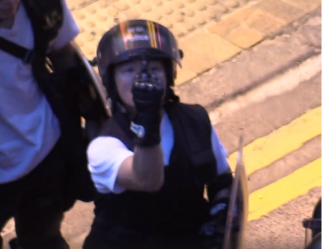 便衣港警對中大學生記者比中指挑釁，且不斷以強光照射阻撓拍攝。   圖：翻攝自中大學生報臉書
