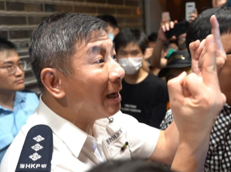 30日天水圍爆發警民衝突，大批示威民眾包圍警局，分區助理指揮官麥子強走出警署門外與民眾理論，並以雙手比中指還擊。   圖：擷取自臉書CampusTV，HKUSU 香港大學學生會校園電視