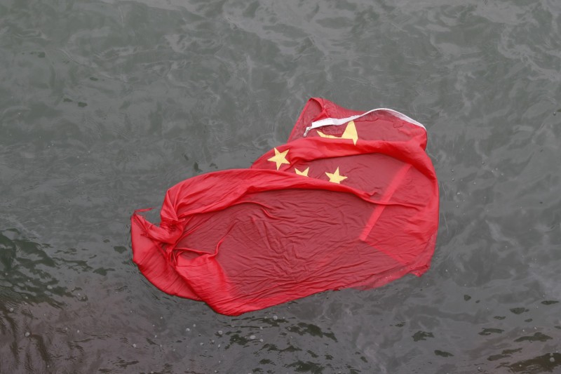 五星旗被示威民眾降下並拋入海中，表達強烈不滿。   圖：美聯社/達志影像