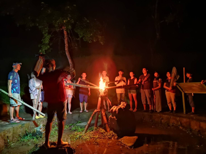 嘉義珈雅瑪青年壯遊點火祭體驗，在夜晚高舉火把，沿著溪水聲走向水火同源區。   圖：教育部／提供