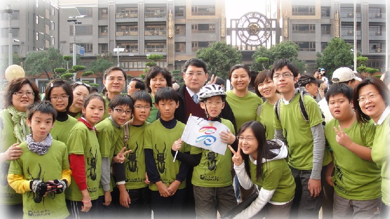 圖為李穆生(中)跟小學生拍照(資料照片)。   擷取自高雄市環境保護局官網