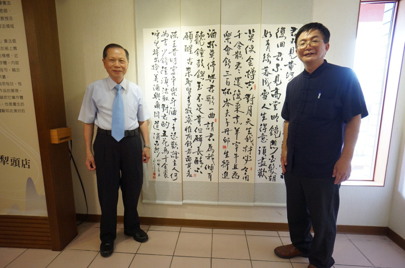 董事長蕭清杰稱讚石遠誠的書法造詣很高，兩人在作品前合照留念。    圖 : 萬和宮/提供