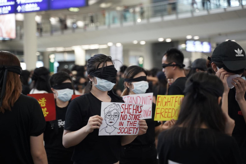 香港「反送中」機場集會，傍晚發起「靜默示威行動」， 現場數千名市民以黑布或手遮蓋口眼、靜默站立，抗議香港人被噤聲、打壓，以及一切政府無理行為。   圖：翻攝譚文豪 Jeremy Tam臉書