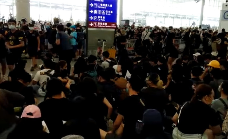 香港機場下午1時起再度湧入千餘人聚集機場大廳集會靜坐，促請香港政府回應民間五大訴求。   圖：翻攝臉書直播