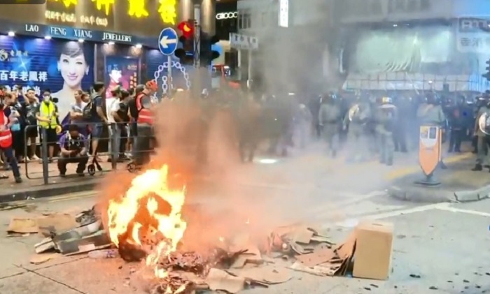 香港今（6）日晚間再度爆發警民衝突！示威者再度圍堵旺角警署，警方施放催淚彈驅離，群眾憤而縱火，目前仍持續對峙中。   圖：翻攝香港電台視像新聞畫面