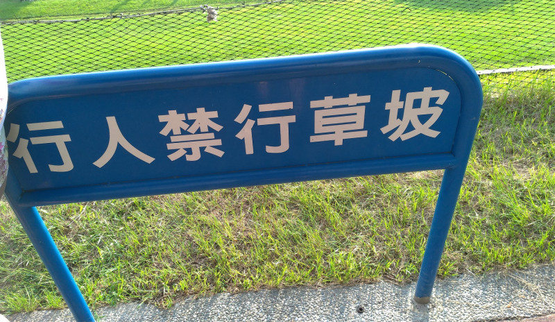新北市三重幸福水漾公園設有不少「行人禁行草坡」的警示標語   圖：讀者提供