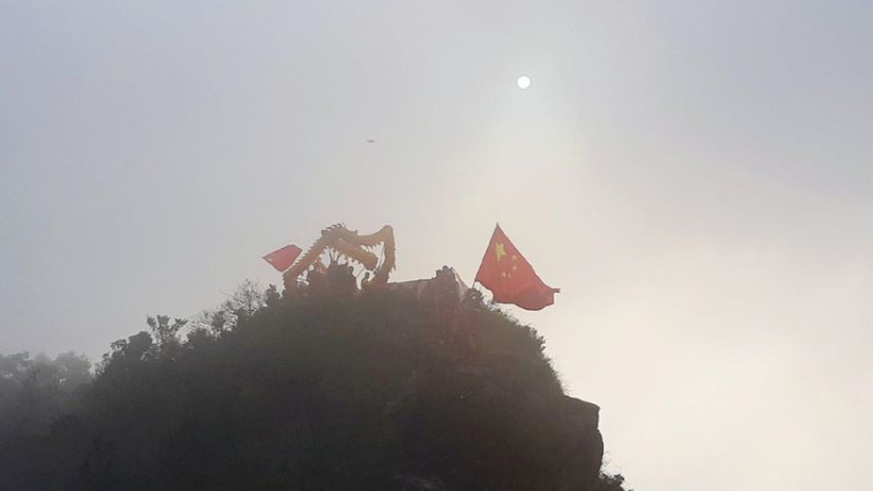 照片中有人在山脊舉五星旗舞龍。   圖：翻攝自Hong Kong Autonomy Action - 香港自治行動臉書