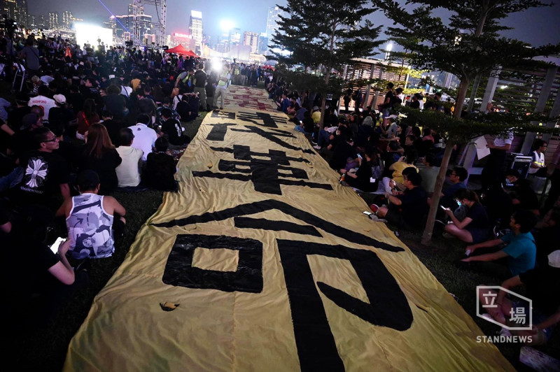 香港民陣28日晚間在添馬公園發起「928反抗威權 迎接黎明」集會，民眾在布條上寫著「時代革命」。   圖／擷取自立場新聞臉書。
