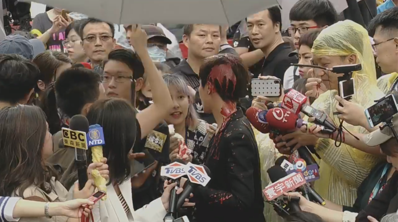 可以看見何韻詩的頭髮、衣服「染紅」，連現場媒體記者也遭到波及。   圖：翻攝自香港邊城青年臉書