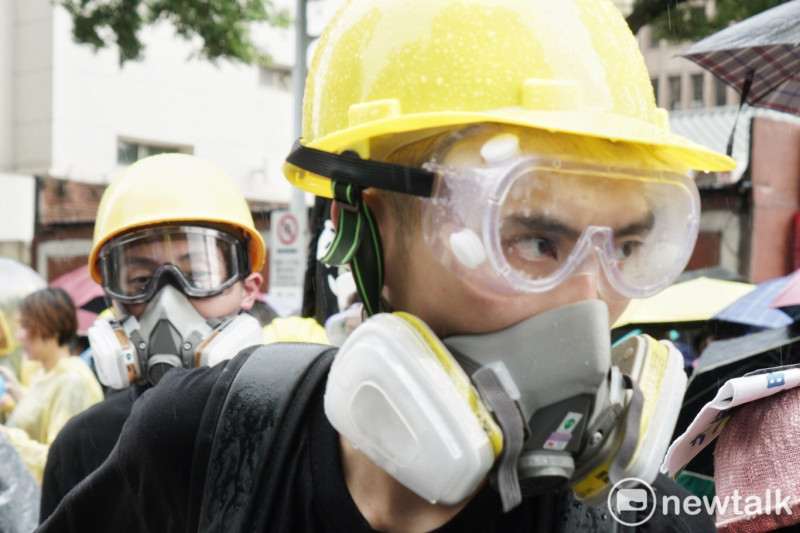 「929撐港大遊行」中，有部分年輕遊行者，不但頭戴工地安全帽，更戴上防毒面罩，致敬香港的示威者。   圖：張良一/攝