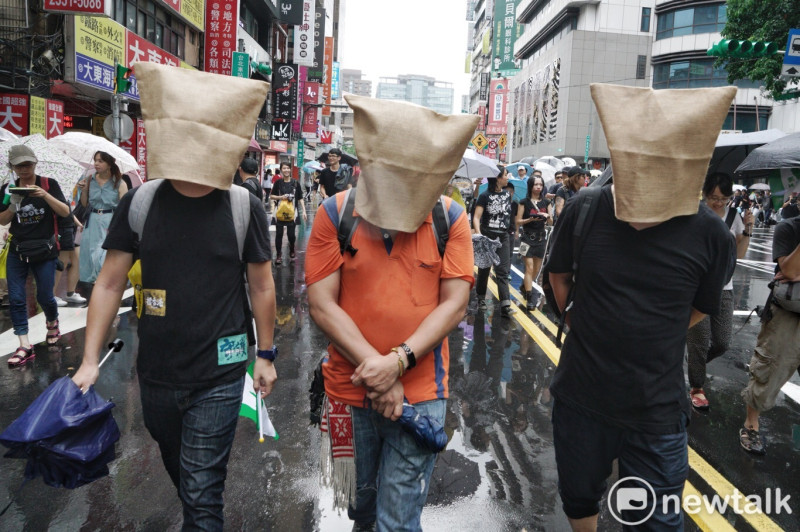 「929撐港大遊行」中，有民眾頭戴麻布袋，暗諷香港政府越權抓捕香港反送中示威民眾。   圖：張良一/攝