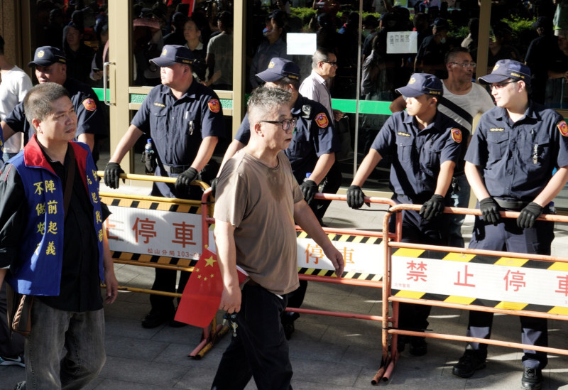 統促黨慶祝中國70週年國慶活動結束後，參與者拿著五星旗，從容的從一字排開的警察面前離開。   圖：張良一/攝
