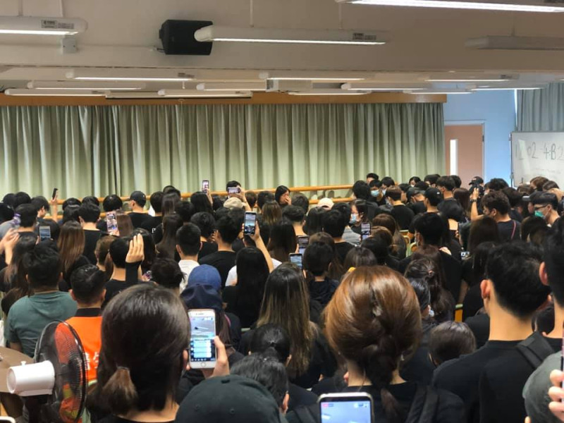 香港1年輕人遭到港警近距離開槍，數百名黑衣人前往中槍學生的學校－－何傳耀紀念中學靜坐抗議，校方緊急說明。   圖：翻攝有傘•友聚臉書