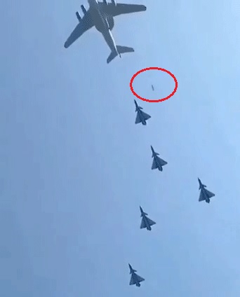 中國微信社群網站傳出1段影片，指出中國閱兵時，飛行隊伍的機艙門意外掉落（紅圈處）。   圖：翻攝自YouTube/德國之音Die Stimme Deutschlands
