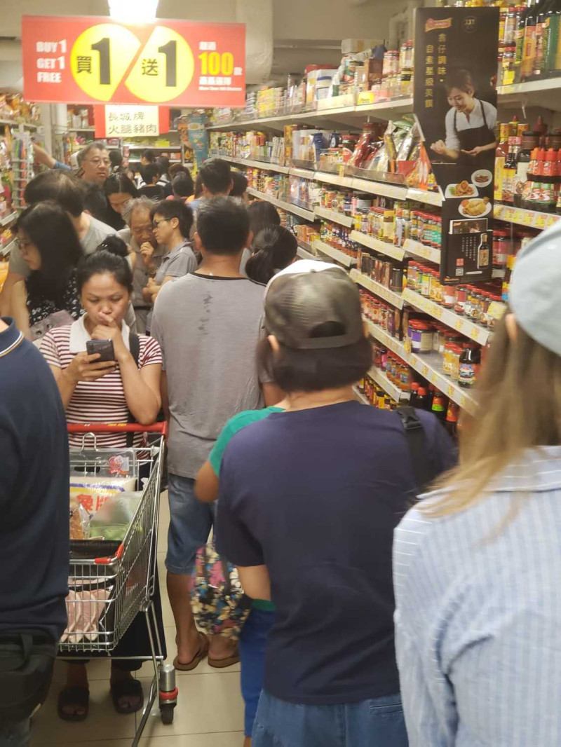 香港超商收銀機前民眾大排長龍，等待結帳。   圖：翻攝星島日報