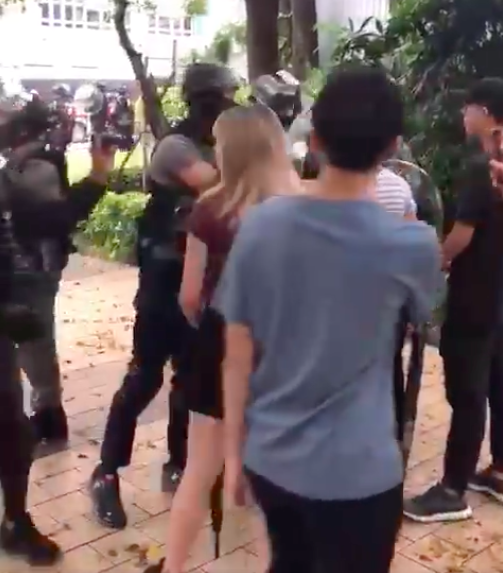 港警進入浸會大學，防暴警察遭到多名學生攔阻，雙方發生爭執，有員警舉起手電筒照向學生，並用圓盾牌推撞學生。   圖：翻攝自 Keith Fong臉書。