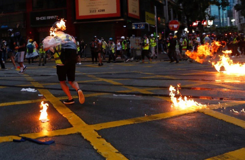 汽油彈波及採訪記者，身上雨衣著火、左邊臉部燒傷。/圖 : 翻攝自香港城市大學學生會城市廣播（CBC）