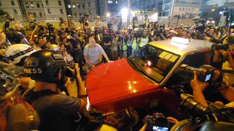 警署外有一輛計程車撞到女子，該計程車隨即被示威者包圍，場面一度緊張。   圖：翻攝星島日報