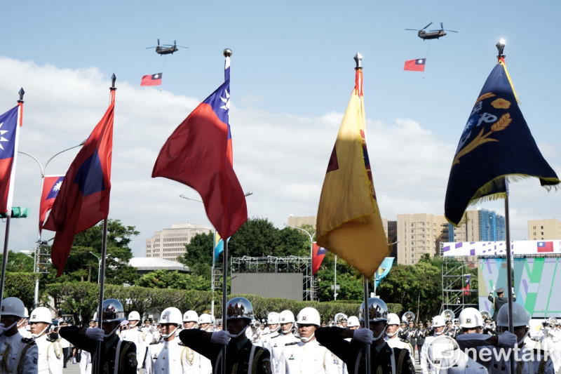 陸軍航空特戰指揮部所屬的兩架CH-47運輸直升機吊掛兩面巨幅國旗,在唱國歌時,編隊通過總統府前。 圖:張良一/攝