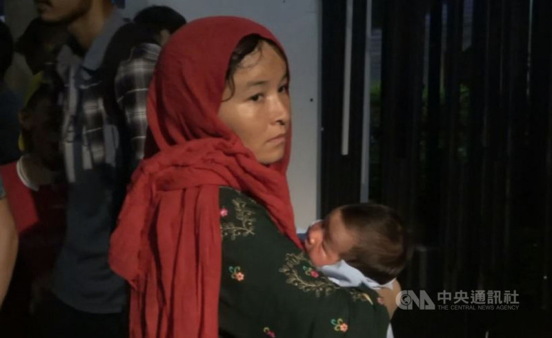 來自阿富汗的難民母親參與10日晚間在聯合國難民署雅加達辦公室前的抗議，手中抱著出生才18天的嬰兒。   圖：中央社提供