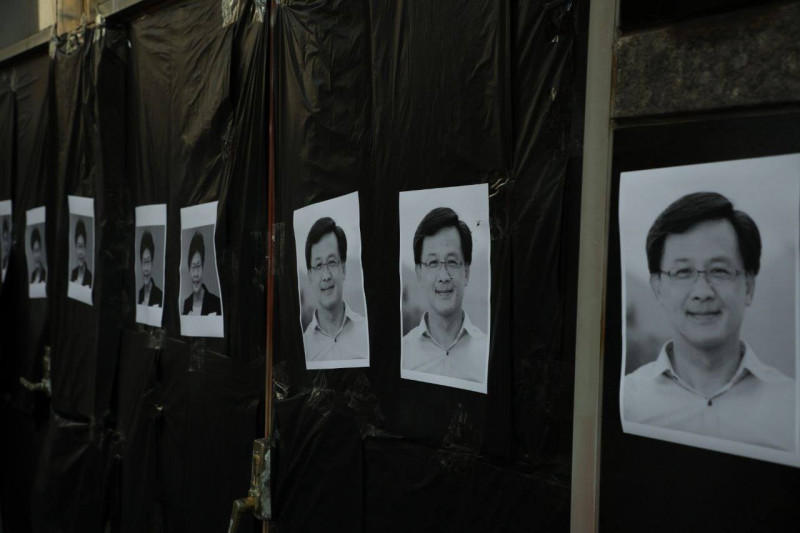 有人在長沙灣政府合署外的鐵門上，貼了許多香港特首林鄭月娥和議員何君堯的黑白照。   圖：翻攝自香港大學學生會校園電視臉書